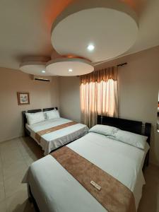 a bedroom with two beds and a large window at Hotel La Leyenda Vallenata in Valledupar +67 photos