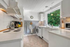 a white kitchen with a sink and a dishwasher at C11259-Hemmet-Raevekrogen-82 in Højsand +25 photos