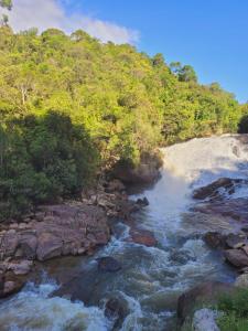 a river with rocks and trees in the background at Casa da Sorte - campo, montanha, natureza e caminho da praia in Santo Amaro da Imperatriz