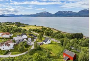 Una vista aérea de un pueblo junto a un cuerpo de agua. en Sigridtunet - 4 bedroom Arctic experiences by the sea, with great opportunities to see the Northern lights dancing just for you!, en Tromsø