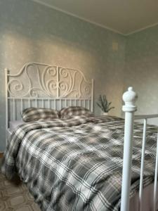 1 dormitorio con cama blanca y manta a cuadros en Sigridtunet - 4 bedroom Arctic experiences by the sea, with great opportunities to see the Northern lights dancing just for you!, en Tromsø