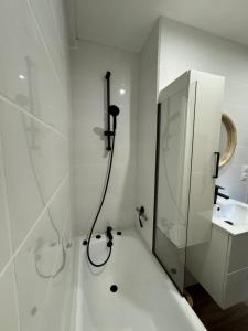 ein weißes Badezimmer mit Dusche und Waschbecken in der Unterkunft Le POP au 17, appartement cosy dans le centre historique de Rodez in Rodez