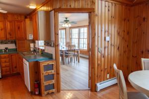 a kitchen with wooden walls and a dining room at Waterside Leisure Lakefront Hot Tub & Game Room in Teall Beach