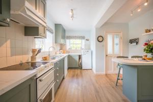 a kitchen with green cabinets and white appliances at Mount Pleasant Farm, Dunwich in Dunwich