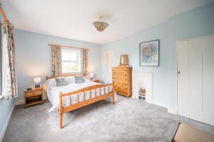 a bedroom with a bed and a dresser and a window at Mount Pleasant Farm, Dunwich in Dunwich