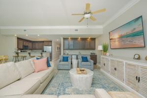 a living room with a couch and a ceiling fan at Phoenix Orange Beach II 1603 condo in Orange Beach
