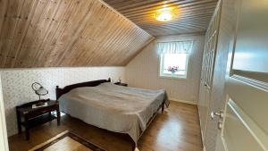 a bedroom with a bed with a wooden ceiling at Viskadalens Gårdshus in Veddige
