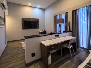 ein Hotelzimmer mit Schreibtisch und Fernseher in der Unterkunft Kathu Hotel in Kathu + 9 Fotos