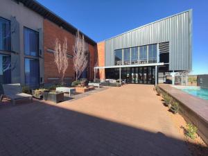 a building with a courtyard with benches in front of it at Kathu Hotel in Kathu