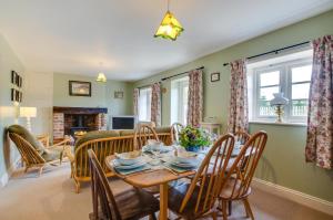 a dining room and living room with a table and chairs at Keepers Cottage in Sall