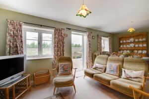 a living room with a couch and a tv at Keepers Cottage in Sall