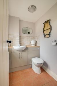 a bathroom with a white toilet and a sink at Keepers Cottage in Sall +13 photos