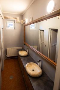 a bathroom with two sinks and a large mirror at La Băiete in Moţăeni