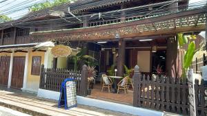 琅勃拉邦RainForest Guest Lodge的房屋设有围栏和桌椅