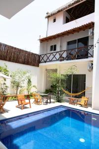 una piscina frente a un edificio con mesas y sillas en Spacious 6 AC Bedrooms Ocean View House up to 16 Guests 7 min walking from Puerto Escondido Best Beaches Playa Coral Bacocho y Carrizalillo, en Puerto Escondido