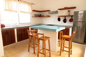 cocina con encimera con 2 sillas y nevera en Spacious 6 AC Bedrooms Ocean View House up to 16 Guests 7 min walking from Puerto Escondido Best Beaches Playa Coral Bacocho y Carrizalillo, en Puerto Escondido 15 fotos más