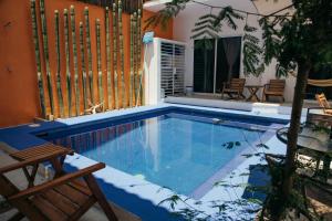 una piscina con dos sillas y una valla en Spacious 6 AC Bedrooms Ocean View House up to 16 Guests 7 min walking from Puerto Escondido Best Beaches Playa Coral Bacocho y Carrizalillo, en Puerto Escondido