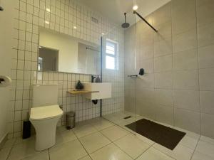 a bathroom with a toilet and a shower with a mirror at Aviator's Nest in Kempton Park +7 photos