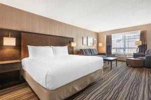 a hotel room with a large bed and a chair at Best Western PLUS Calgary Centre Inn in Calgary +31 photos
