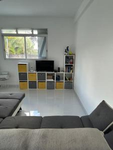 a living room with a couch and a television at Villa FRANNY in Fort-de-France