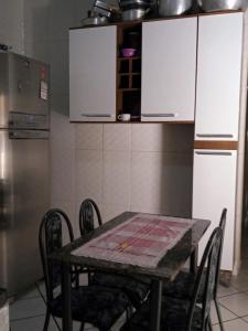a kitchen with a table with chairs and a refrigerator at Casa princesa isabel in Porto Seguro