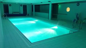 a large swimming pool with blue lighting in a room at Le Roi du Sundgau près de la Horse - Mooslargue in Mooslargue