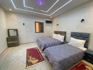 a room with two beds and a mirror at Résidence Tfraoute in Tafraoute