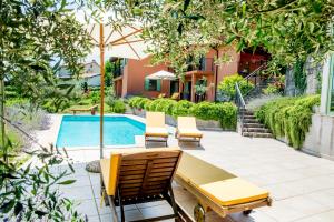 une terrasse avec des chaises, une table et une piscine dans l'établissement Zoi Apartments, à Dobrovo