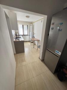 a kitchen with a refrigerator and a table at HomeLand3 in Bîrlad