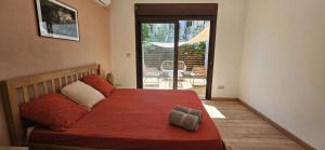 a bedroom with a bed with a red comforter at Casamila - Charmant T3 à deux pas de la plage in Saint-Pierre