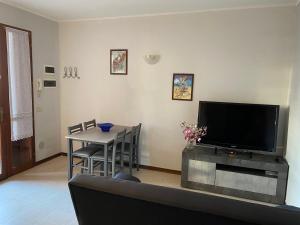 a living room with a television and a table with chairs at Appartamento indipendente Maranello vicino Ferrari in Maranello