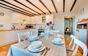 a kitchen and dining room with a table and chairs at Castle Point Cottage Craster in Craster