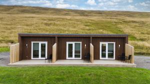 a small building with chairs on a field at Brandsstaðir, gistihús í Blöndudal in Bólstaðarhlíð