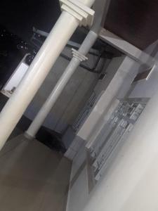 une pièce avec des tuyaux blancs, des tables et des chaises dans l'établissement Motel, à Kigali