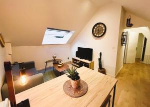 ランスにあるAix - Cocon élégantのリビングルーム(テーブル、壁掛け時計付)