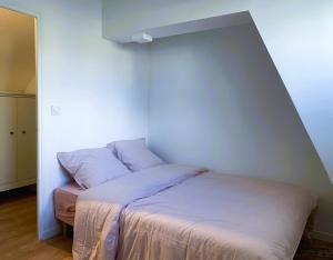 ランスにあるAix - Cocon élégantの白い壁のドミトリールームのベッド1台分です。