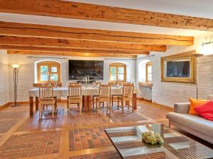 un salon avec une table, des chaises et un canapé dans l'établissement Historisches Bauernhaus mit Show-Küche & Kamin, à Fürstenzell