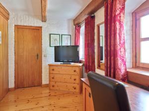 - un salon avec une télévision sur une commode en bois dans l'établissement Historisches Bauernhaus mit Show-Küche & Kamin, à Fürstenzell
