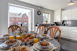 a dining room table with breakfast food and orange juice at Pebble Beach - Felixstowe in Felixstowe