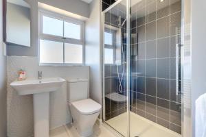 a bathroom with a toilet and a sink and a shower at Pebble Beach - Felixstowe in Felixstowe +29 photos