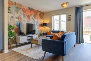 a living room with a blue couch and a tv at Marriott House sleeps 5 in Bourne with parking in Bourne