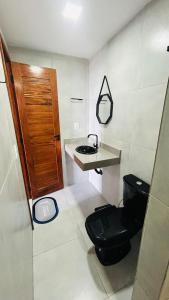 a bathroom with a black toilet and a sink at Mar e Terra Bangalôs in Areia Branca +19 photos
