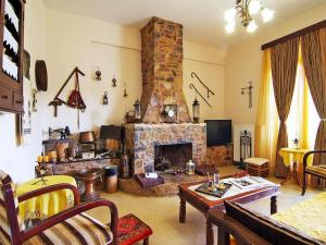 a living room with a stone fireplace and a table at Holiday home with pool in Kalamítsion Alexándrou