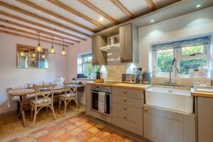 une cuisine avec une table et une salle à manger dans l'établissement Golden Goose Cottage, à Wiveton