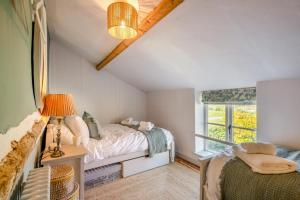 une chambre avec un lit et une fenêtre dans l'établissement Golden Goose Cottage, à Wiveton