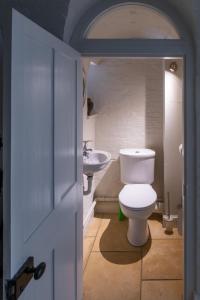 a bathroom with a toilet and a sink at The Triumphal Arch West in Holkham
