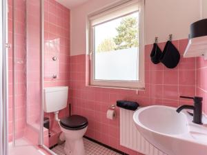 加尔丁Ferienhaus in Garding的带马桶和水槽的粉色浴室 更多20张照片