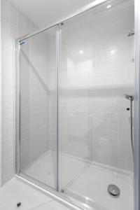 a shower with a glass door in a bathroom at An apartment with a view - Nó's place in Vila Nova de Gaia +45 photos
