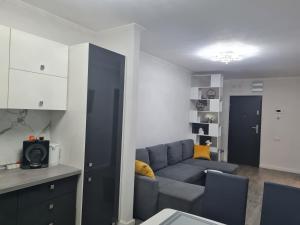 a living room with a blue couch and a kitchen at Glam Apartament Oradea in Oradea