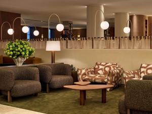 a waiting room with chairs and a table and flowers at Sofitel Sydney Wentworth in Sydney